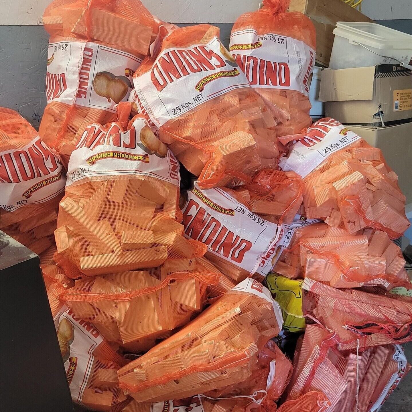 A pile of orange bags full of kindling for sale