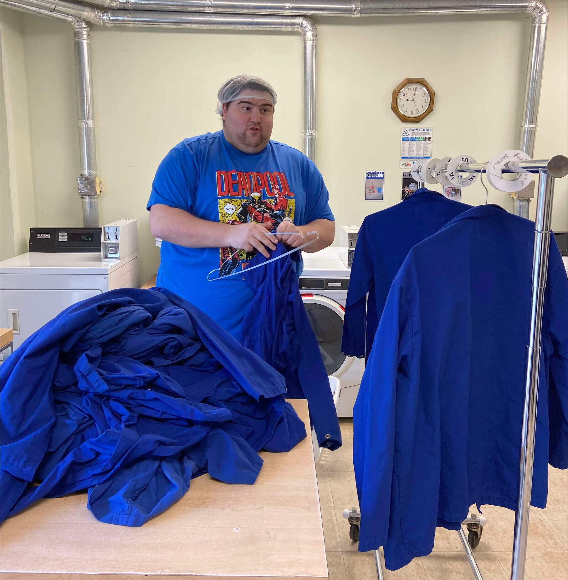 Employee hanging clothes on hangers.